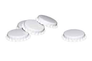 Five white metal crown caps against a white background